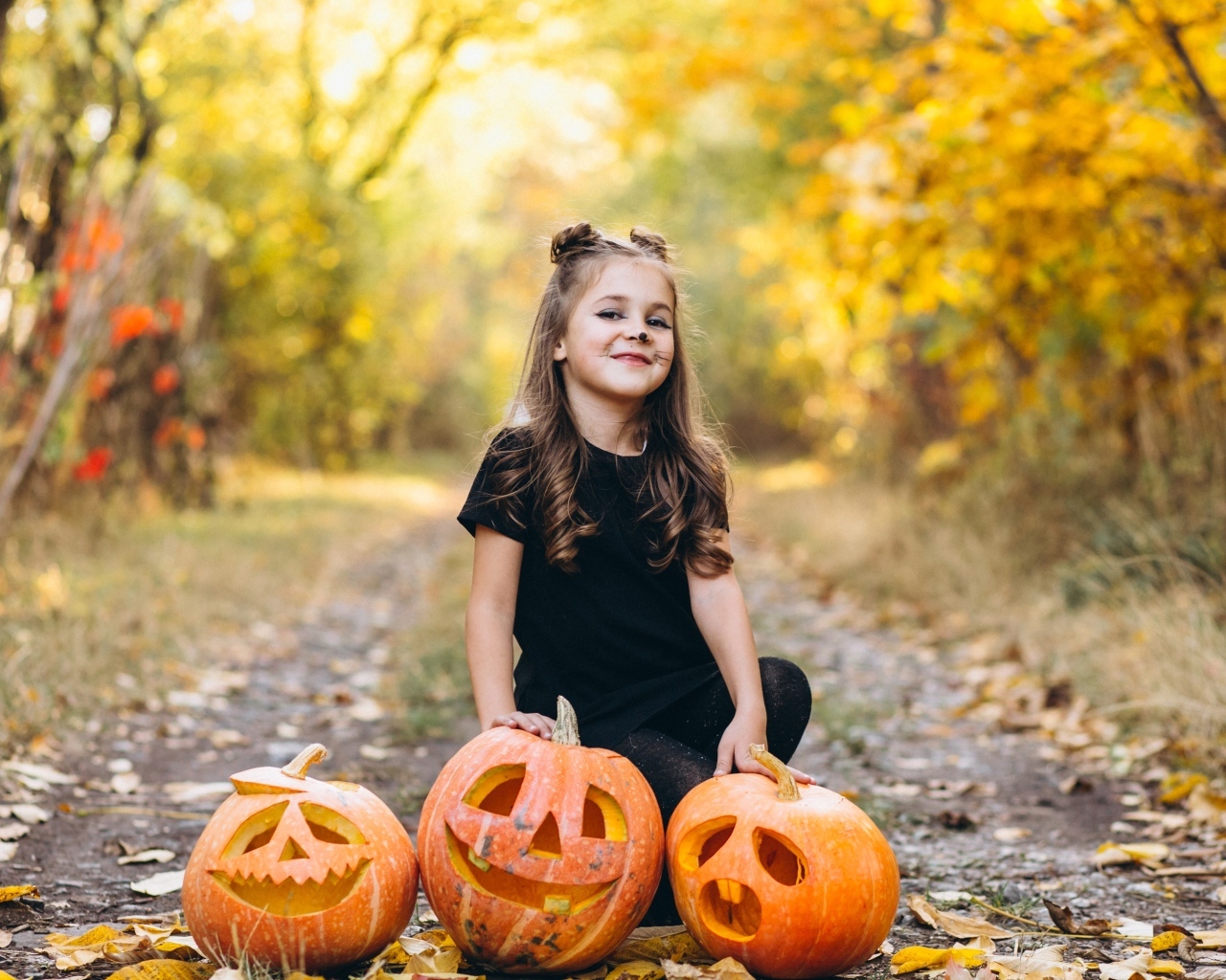 Девочка с тыквой в парке на праздник Хэллоуин