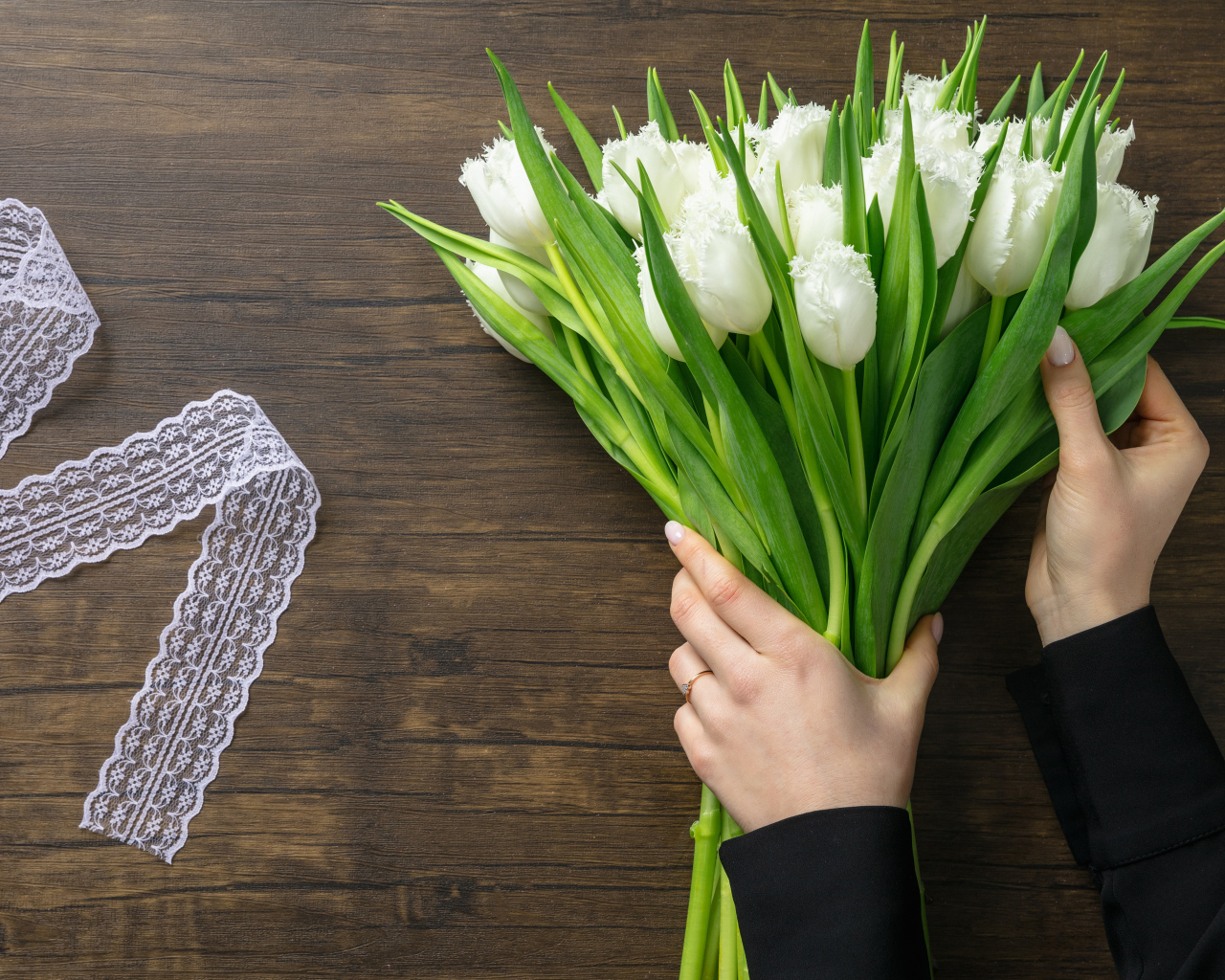 Большой букет белых тюльпанов с лентой на столе на 8 марта