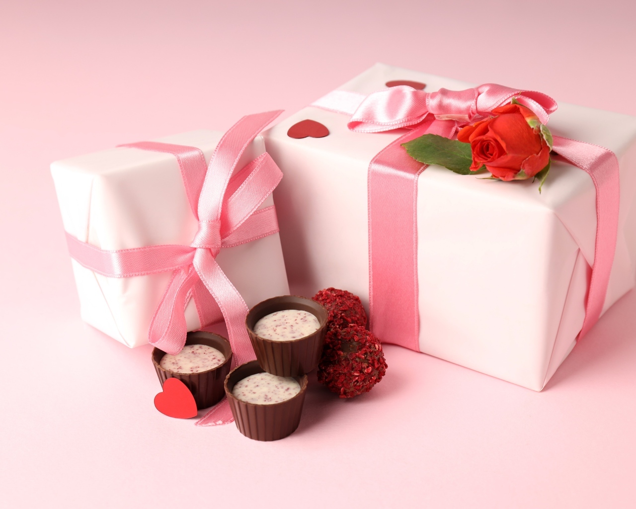 Два подарка с конфетами на розовом фоне на День Святого Валентина