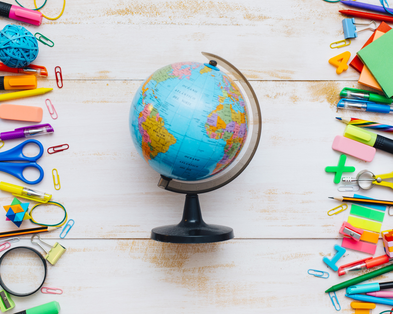Глобус на деревянном фоне с канцелярскими предметами