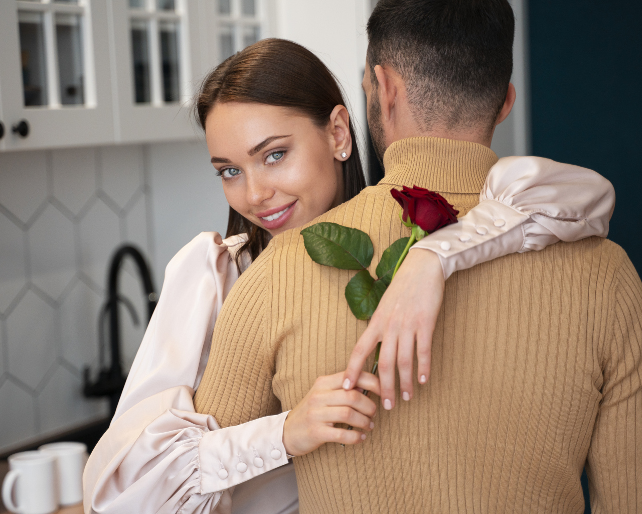 Влюбленная девушка с розой обнимает парня