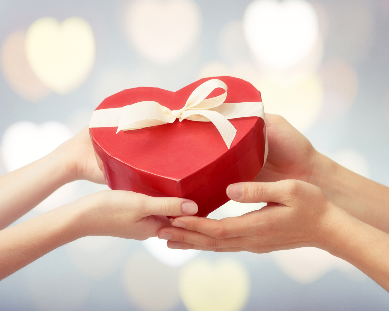 Коробка в форме сердца в руках у пары
