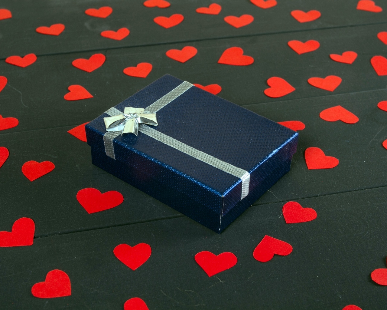 Черная коробка с красными сердечками на столе