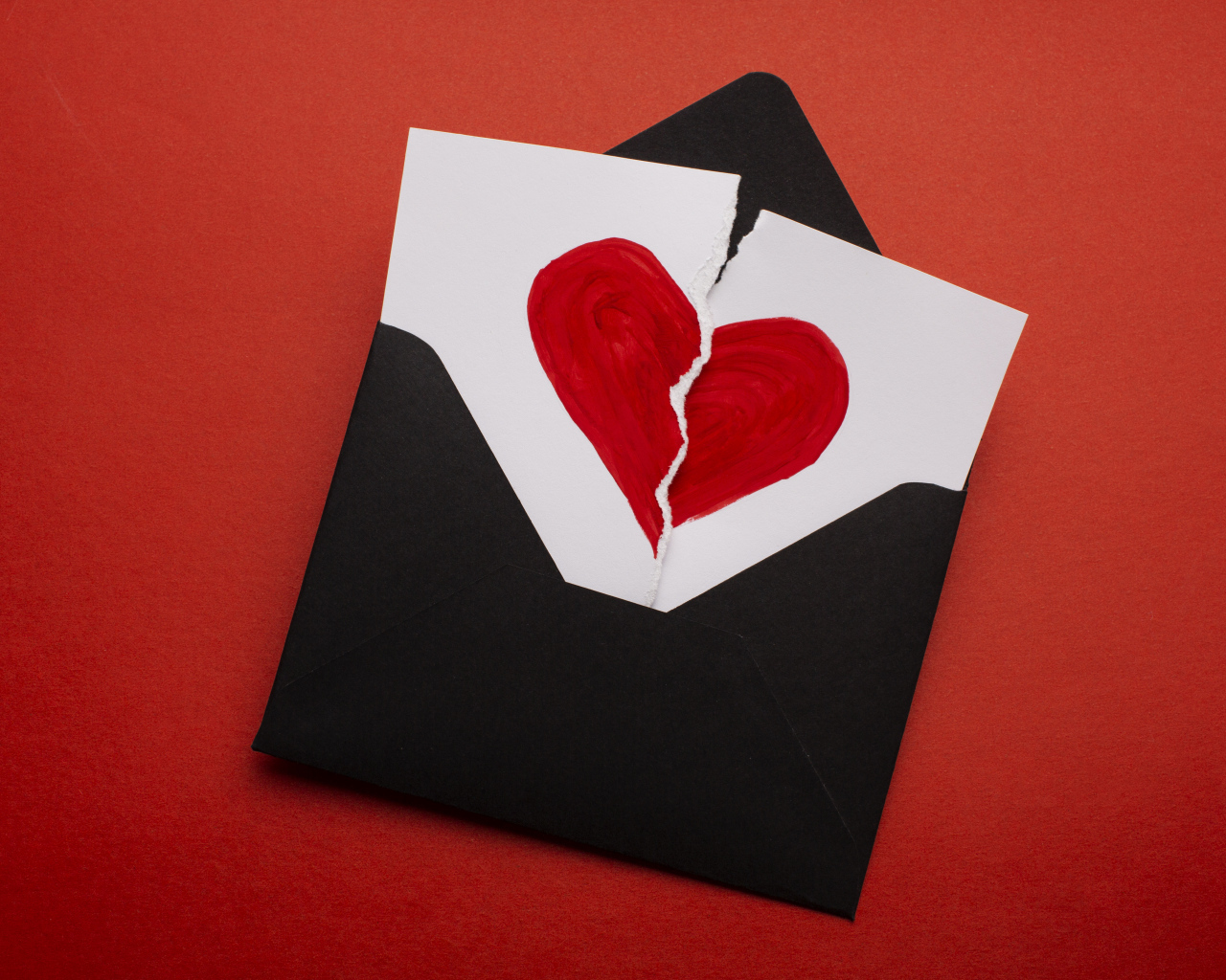 Черный конверт с нарисованным разбитым сердцем