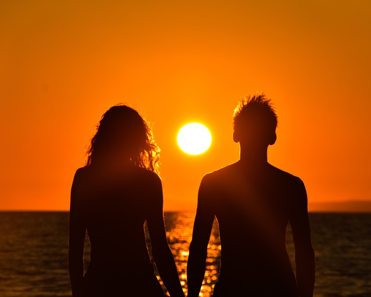 Влюбленная пара на фоне заката у моря
