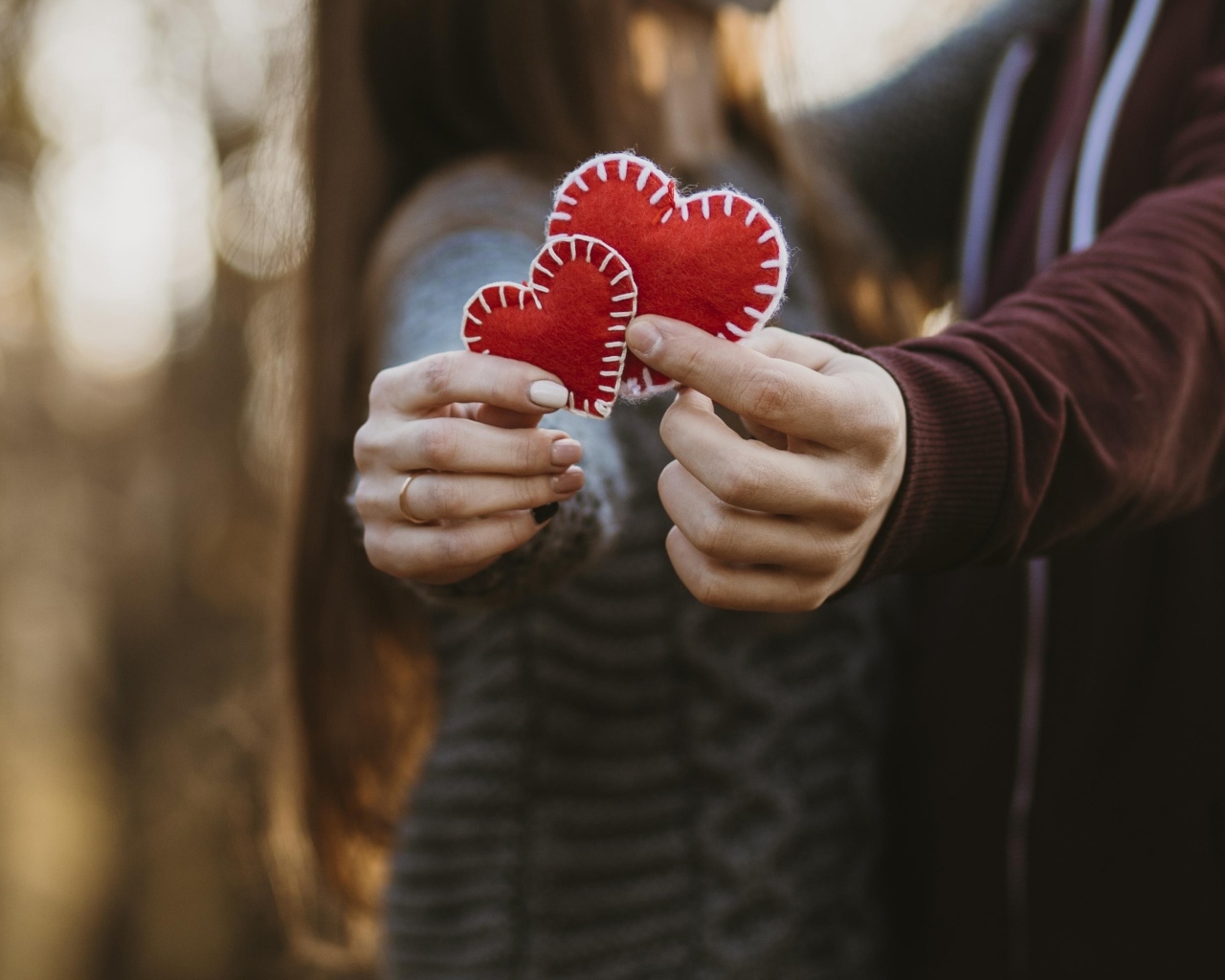 Влюбленная пара держит сердечки в руках