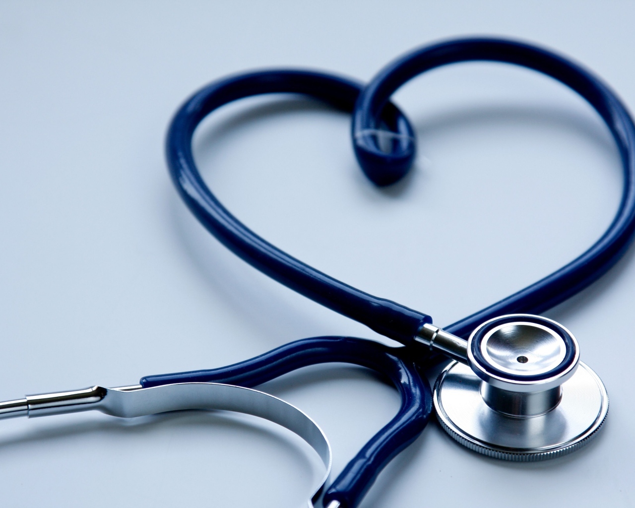 Сердце из стетоскопа на сером фоне