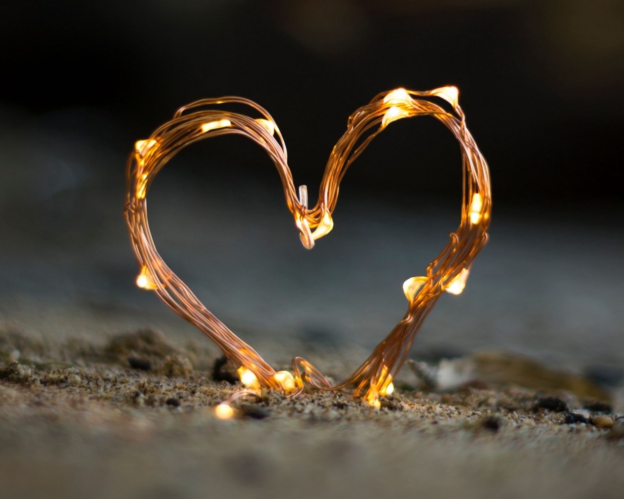 Сердце из гирлянды на песке