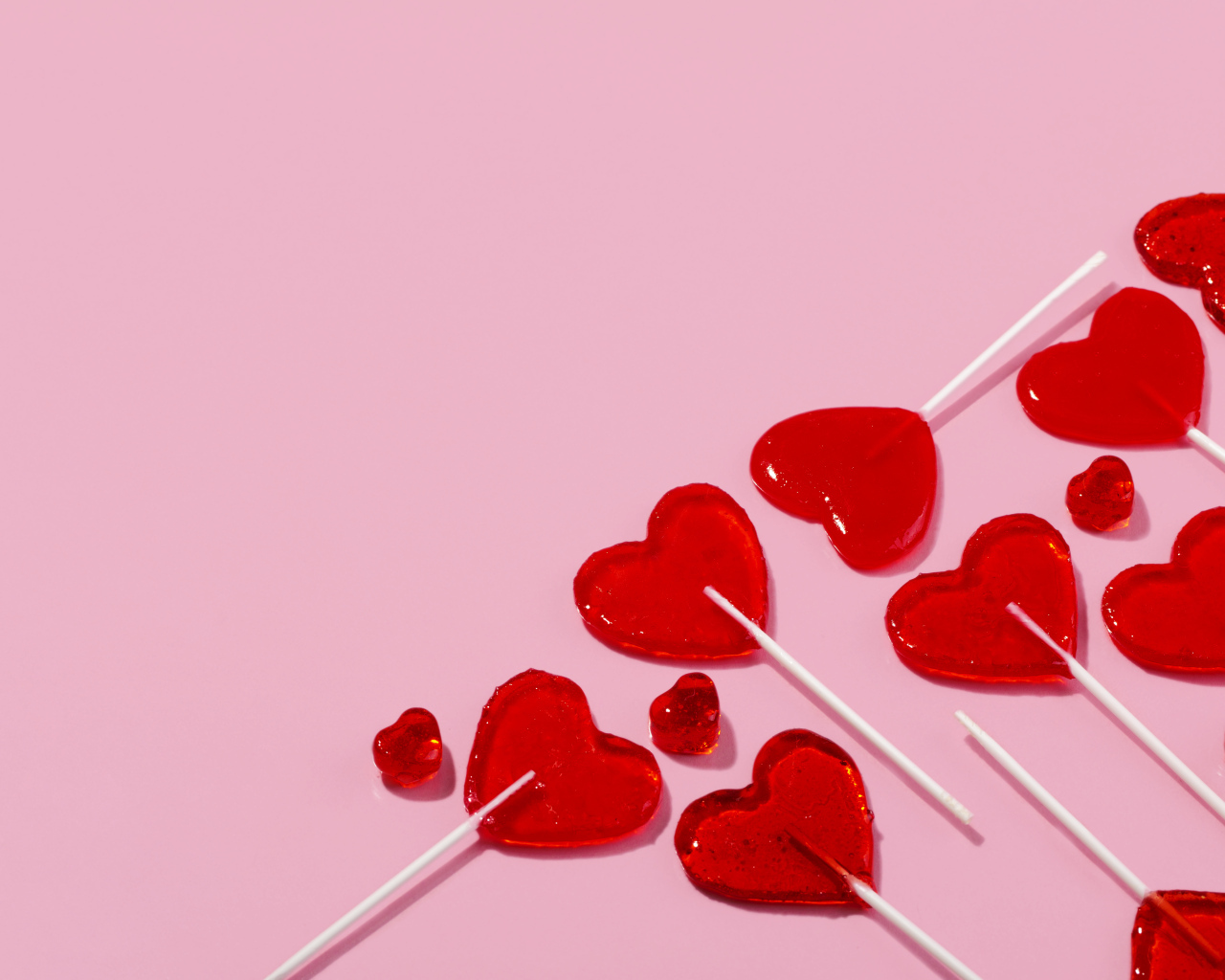 Леденцы в форме сердца на розовом фоне