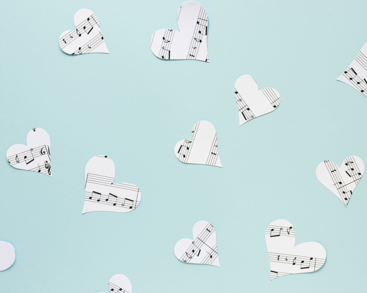 Сердечки из нотной тетради на голубом фоне