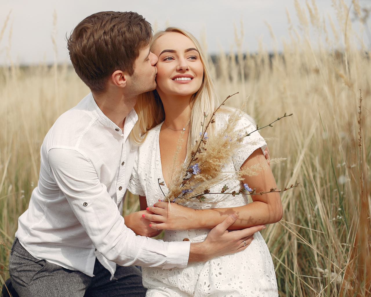 Поцелуй красивой пары на поле