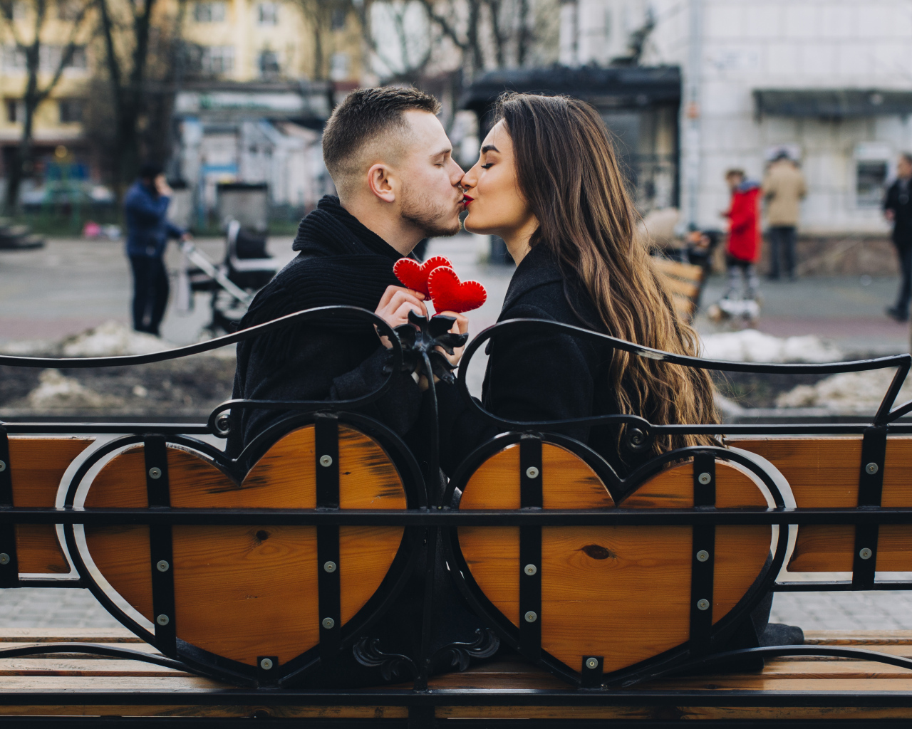 Поцелуй влюбленной пары на лавке в парке