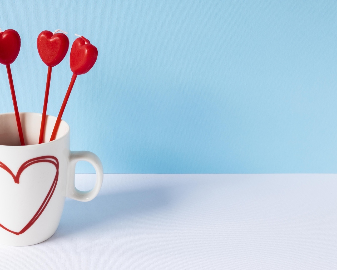 Кружка с сердечками на палочке на голубом фоне