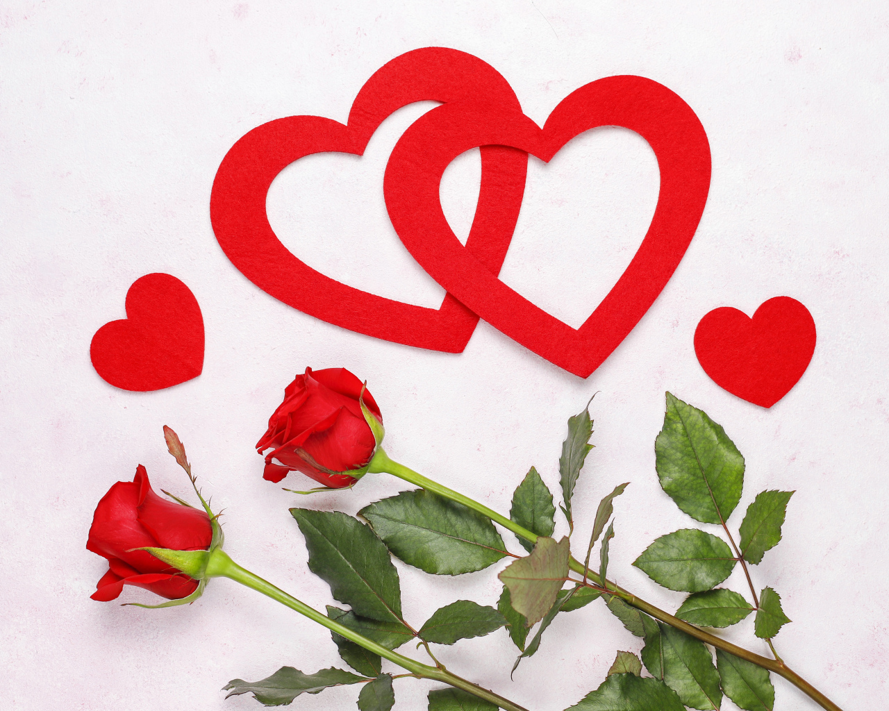 Бумажные сердечки с красными розами на белом фоне