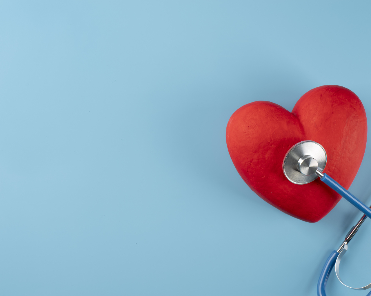 Красное сердце слушают стетоскопом