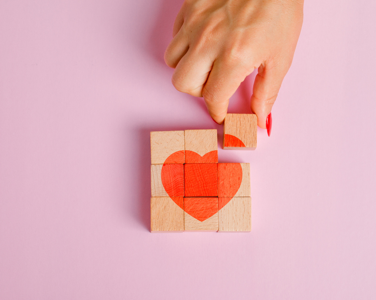 Красное сердце из кубиков на розовом фоне