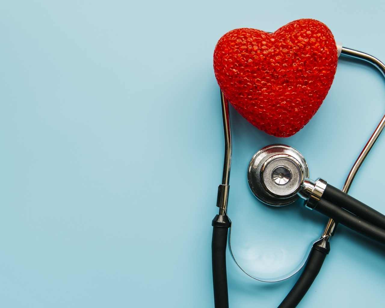 Красное сердце с стетоскопом на голубом фоне
