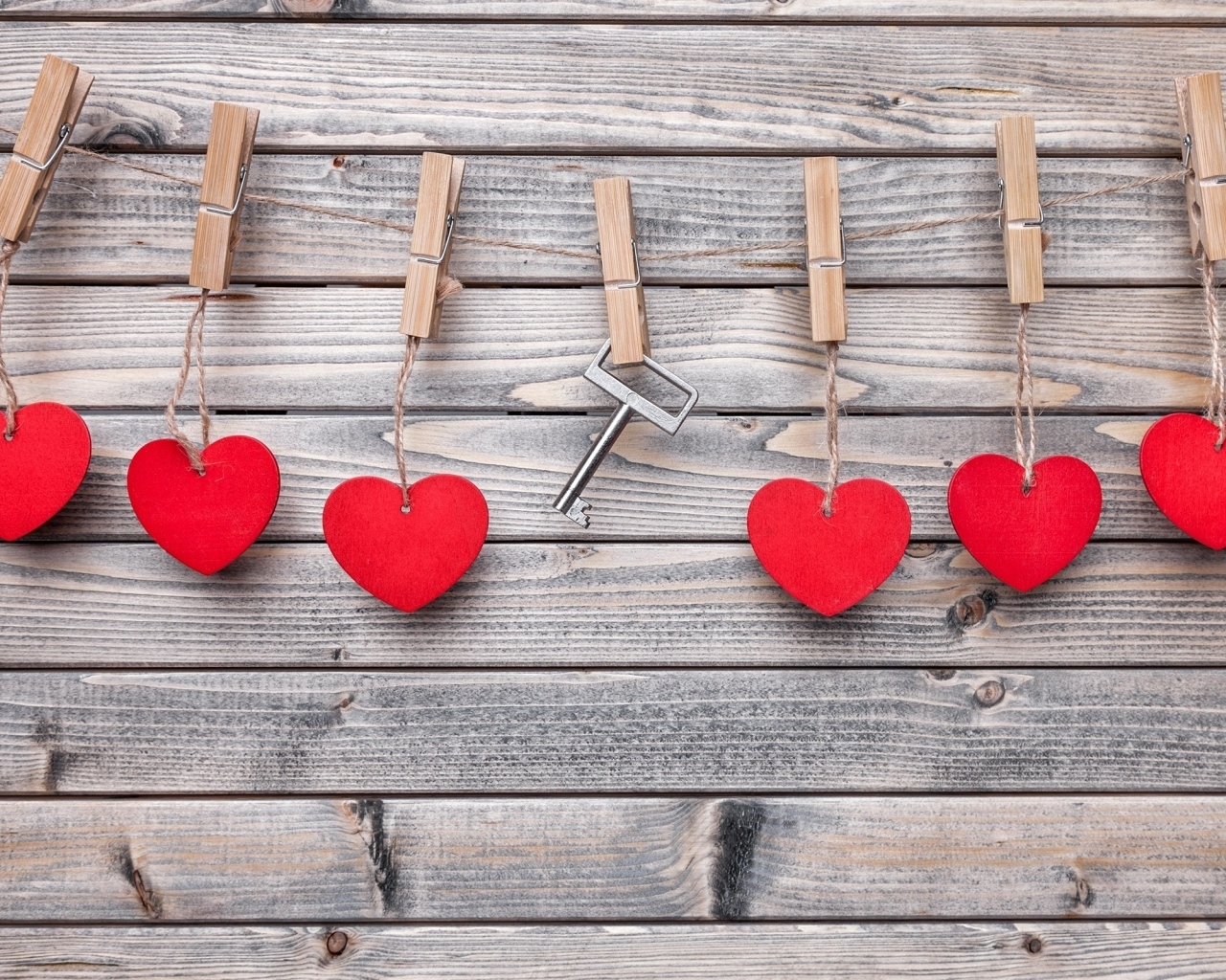 Красные сердечки и ключ с прищепками на веревке