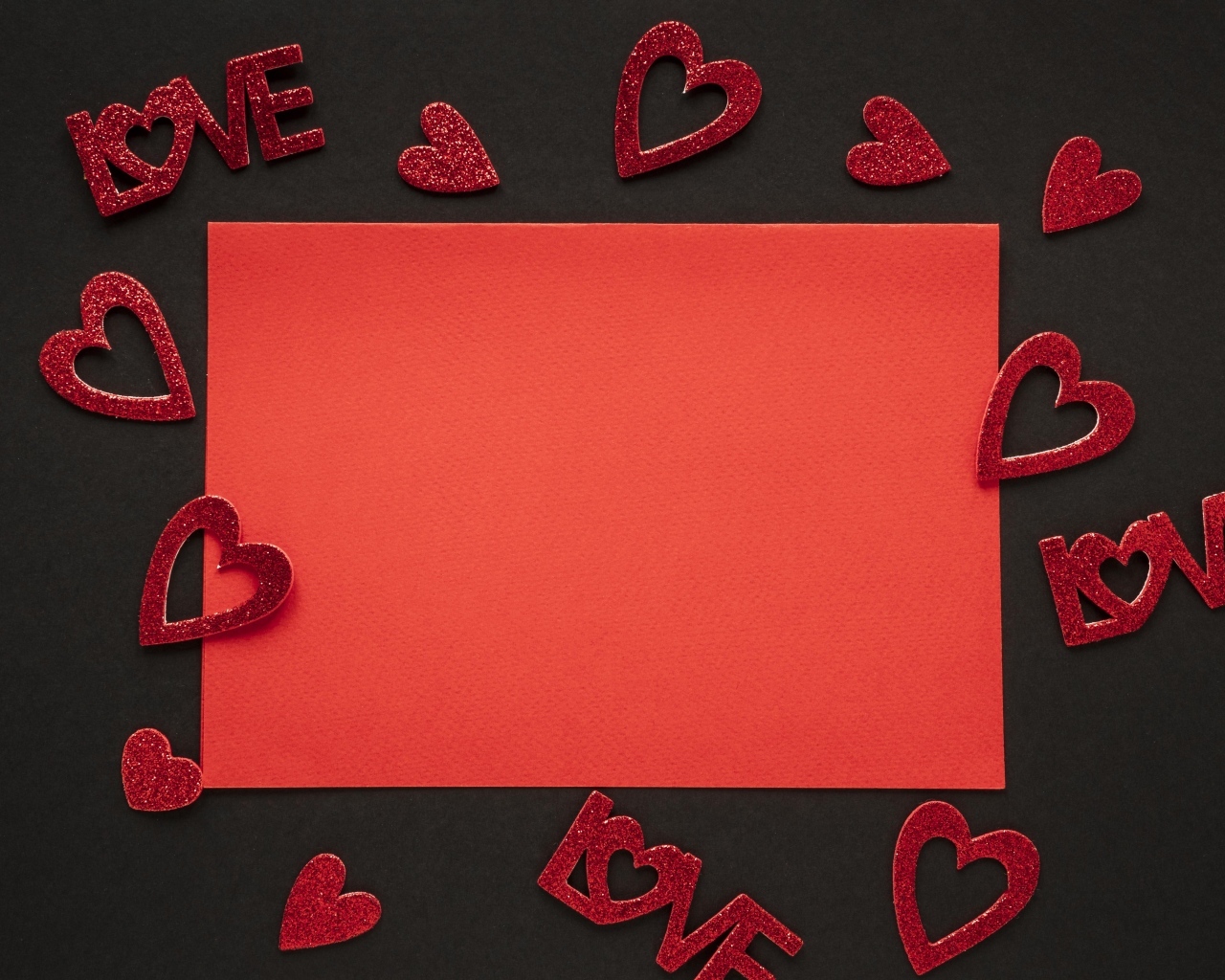 Красный лист бумаги на черном фоне с сердечками, шаблон для открытки