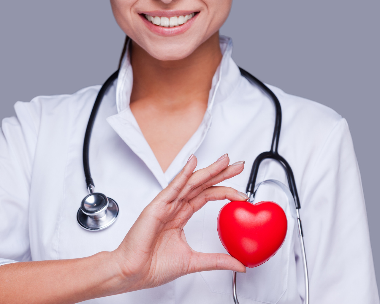Улыбающаяся женщина врач с красным сердцем