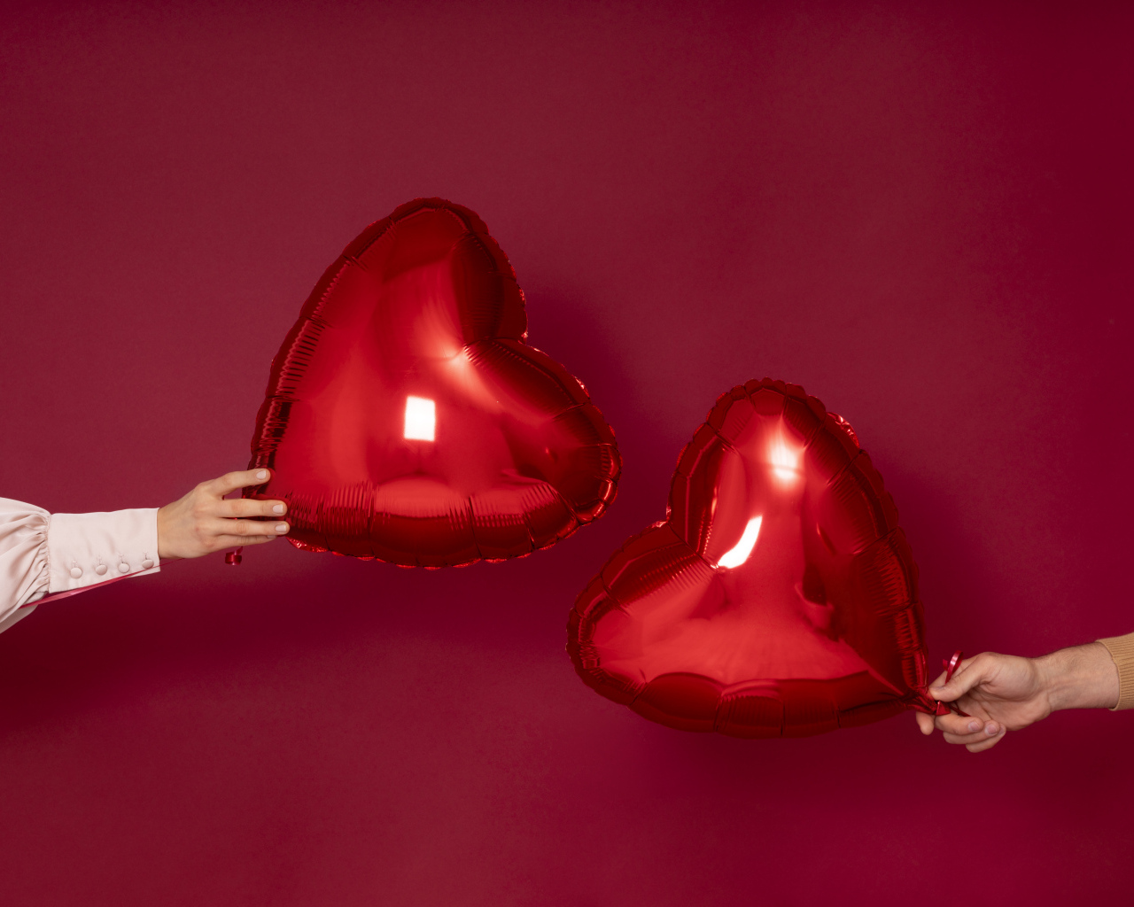 Два воздушных шара в форме сердца на красном фоне