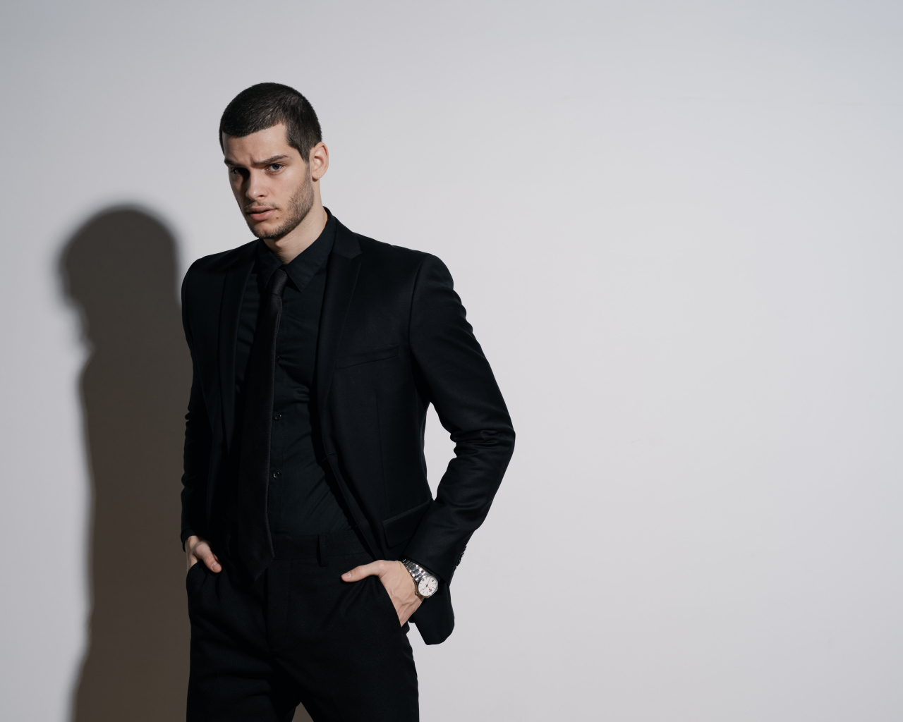 Красивый деловой мужчина стоит у серой стены