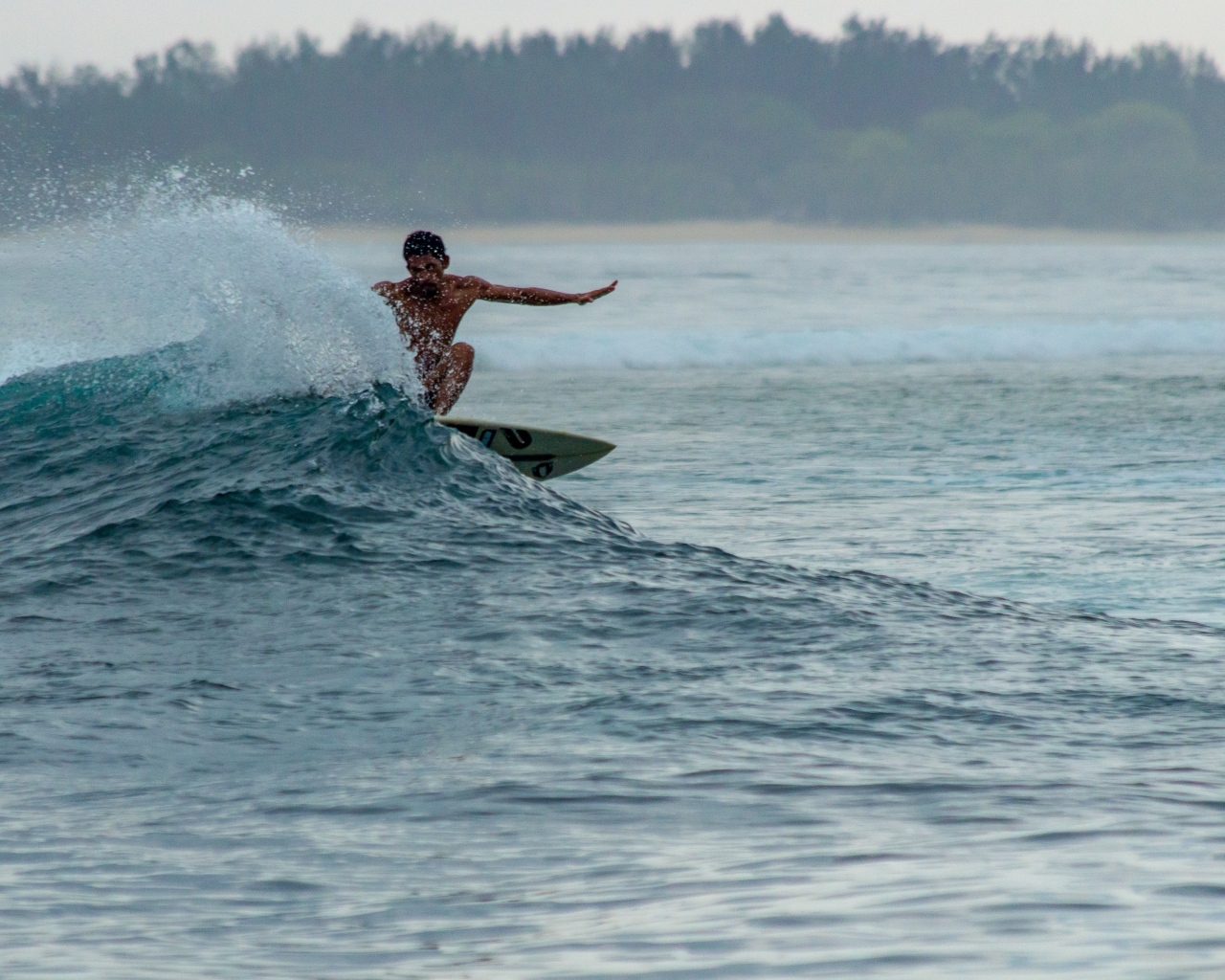 Мужчина серфингист ловит волну