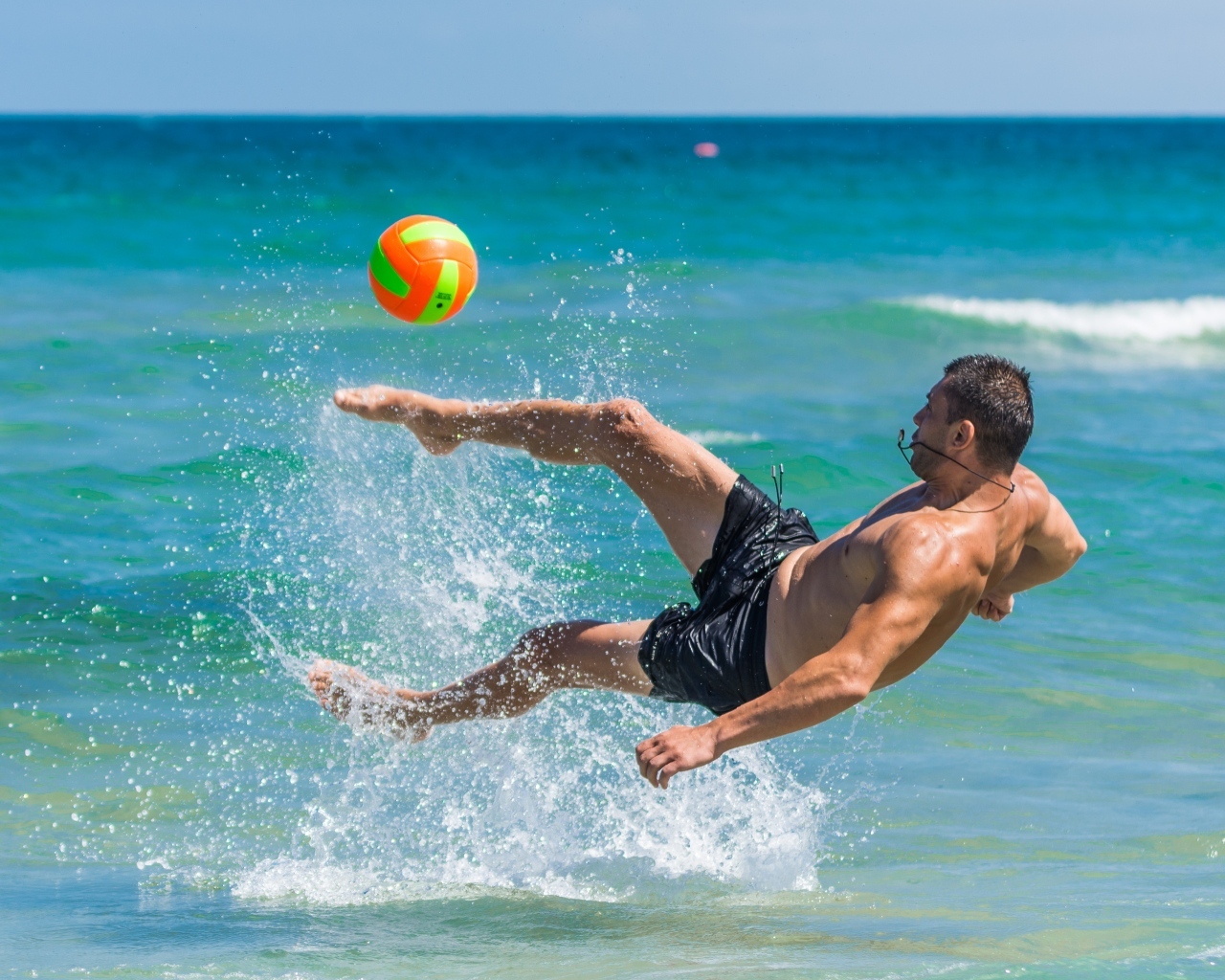 Мужчина играет в пляжный футбол