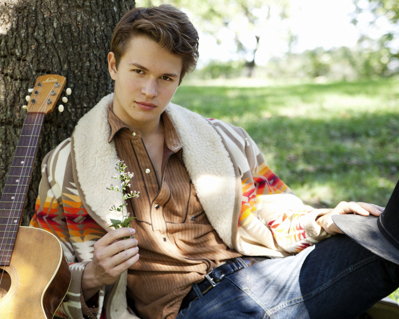 Актер Энсел Эльгорт с гитарой у дерева