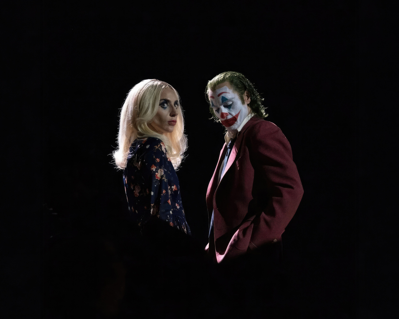 Главные герои фильма Джокер: Безумие на двоих на черном фоне