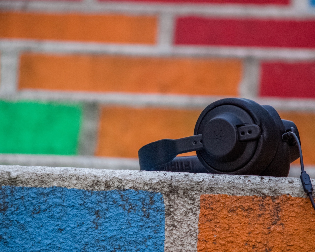 Черные наушники лежат на стене