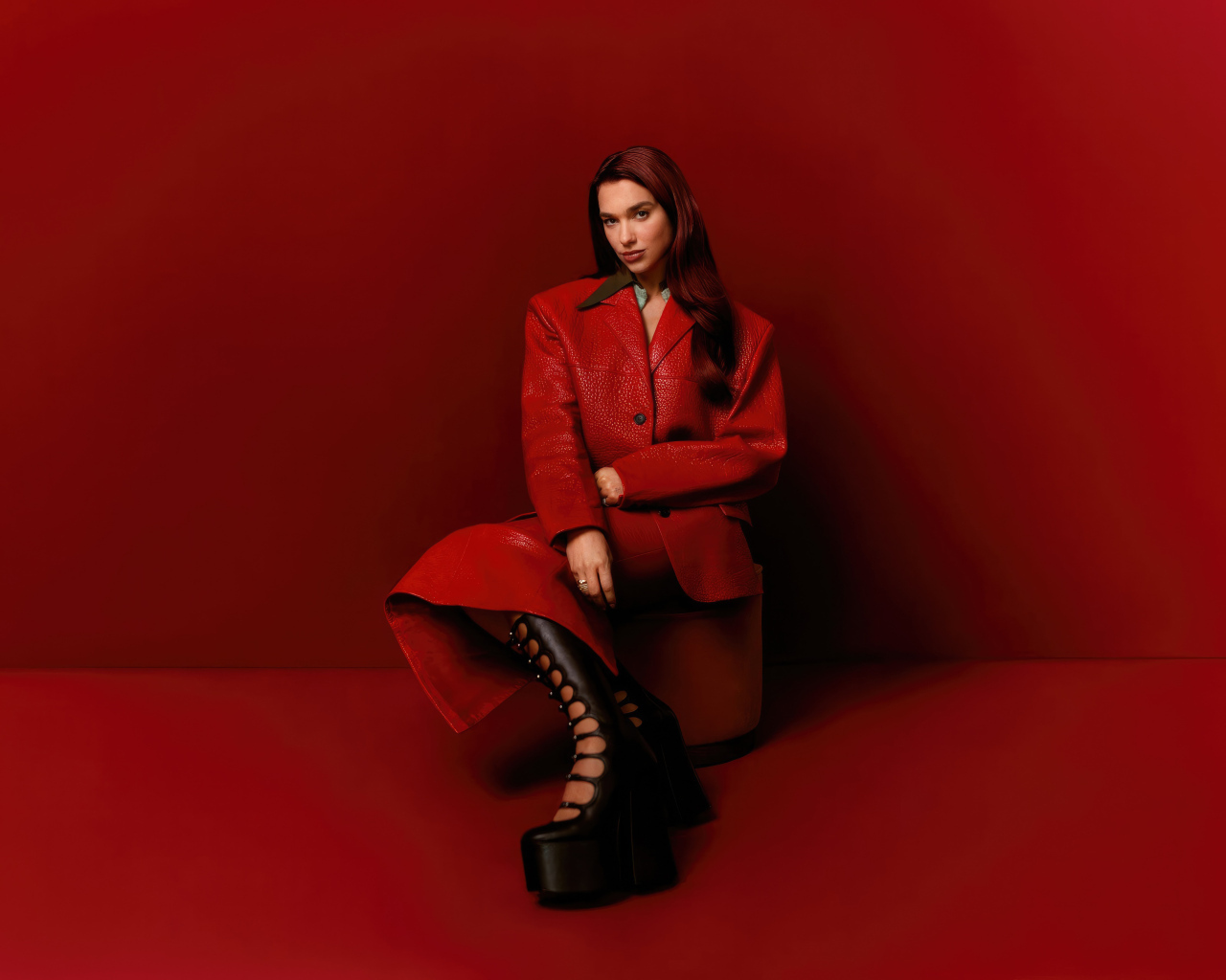 Британская певица Дуа Липа на красном фоне