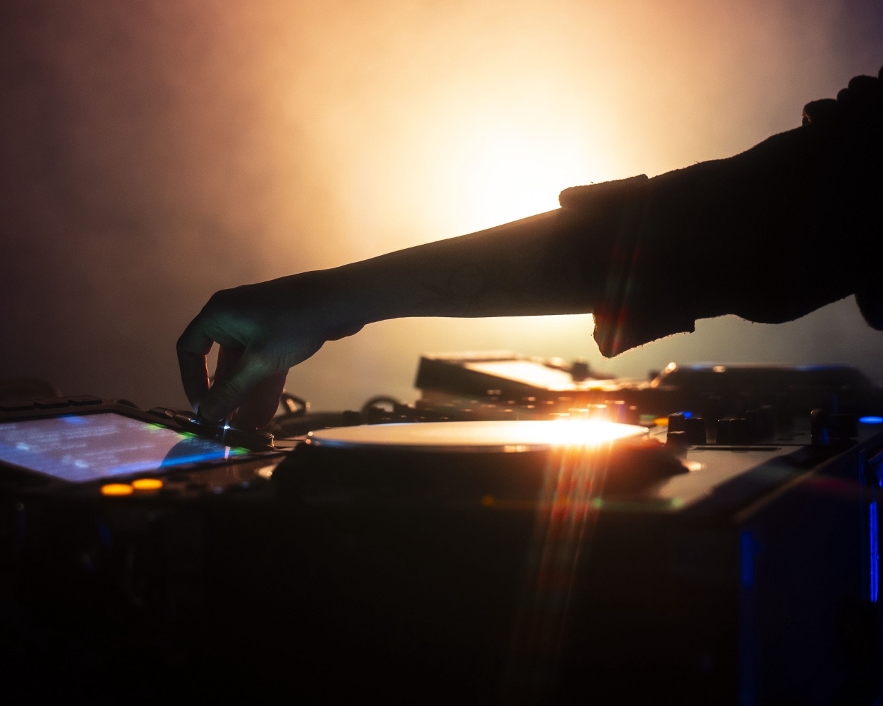 Рука диджея настраивает музыкальный пульт 