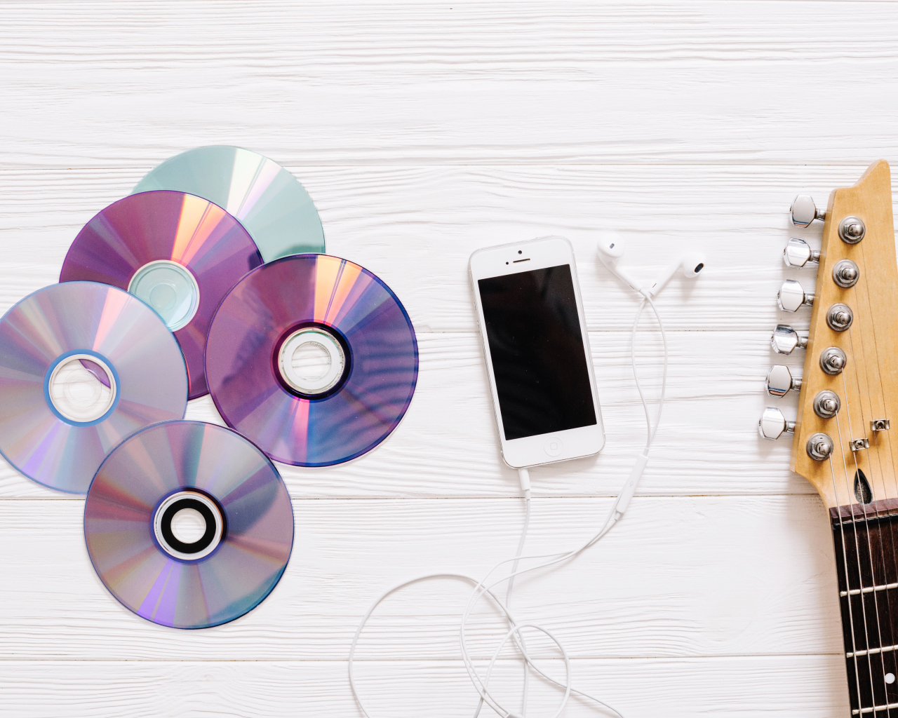 Диски с телефоном и гитарой на белом фоне