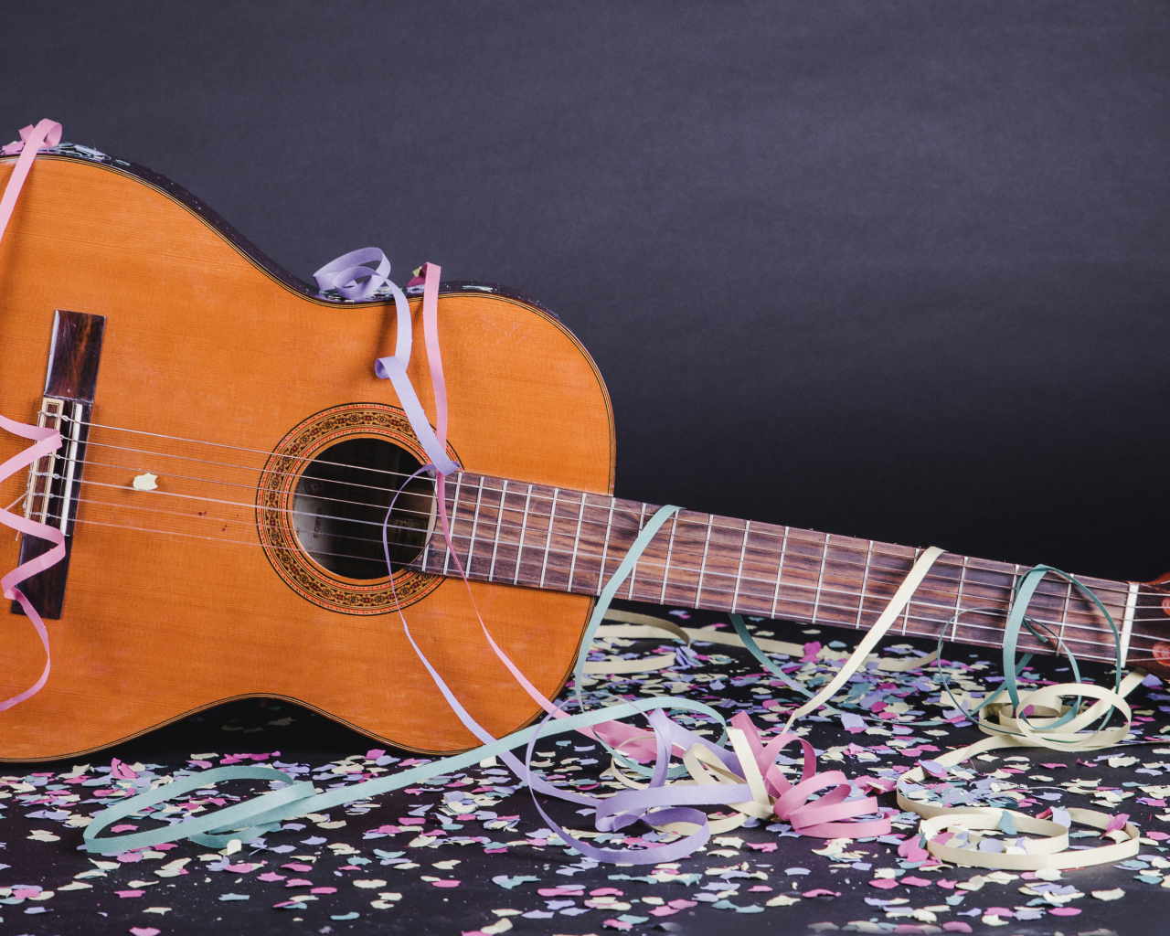 Гитара в конфетти у серой стены