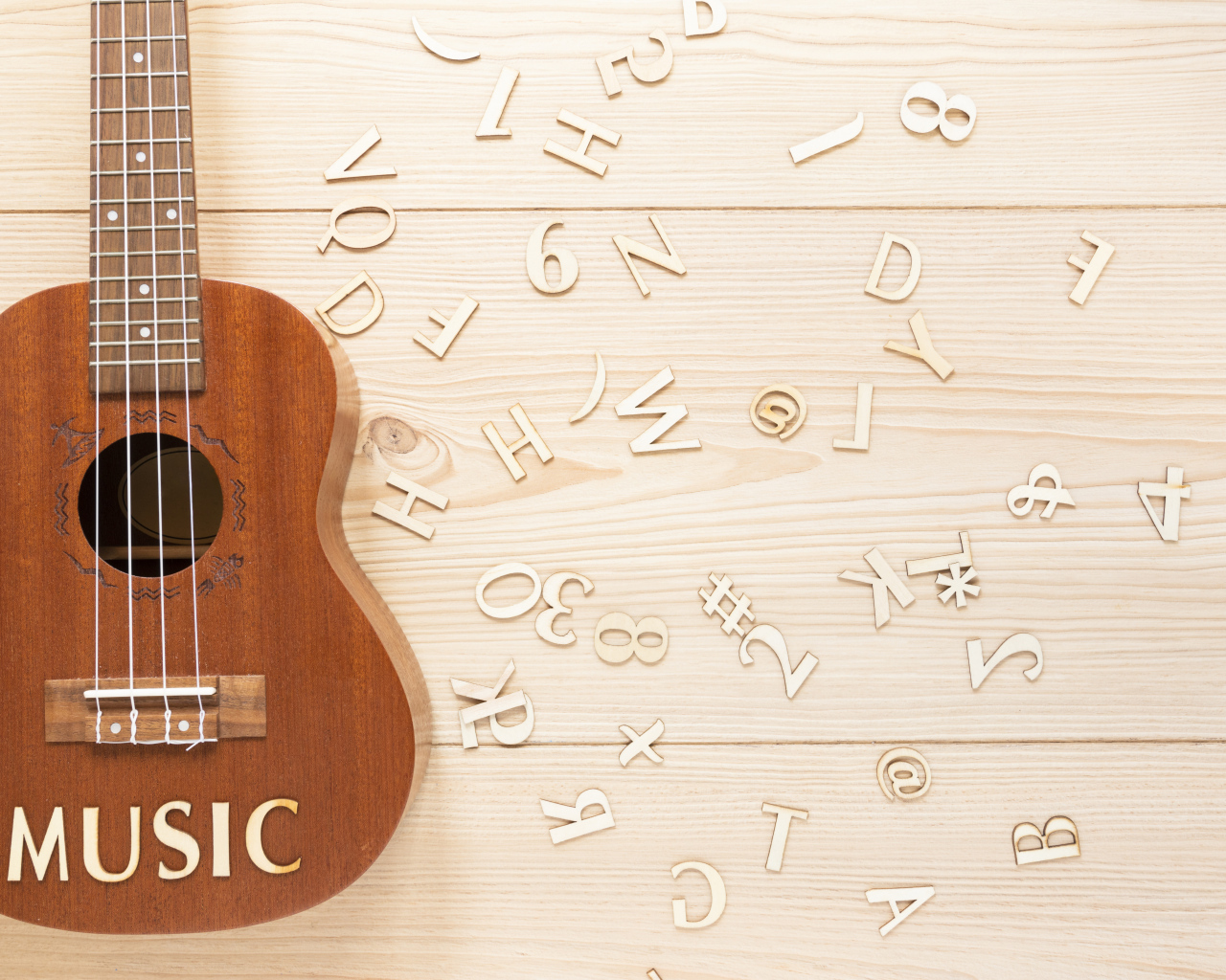 Guitar on a table with wooden letters