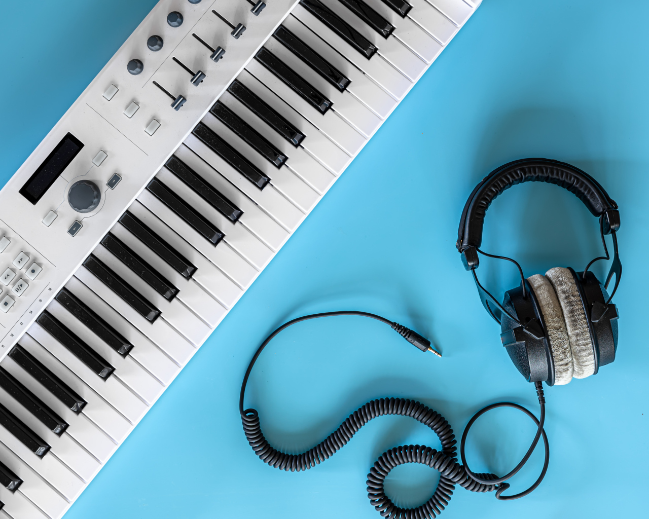 Наушники на голубом фоне с синтезатором