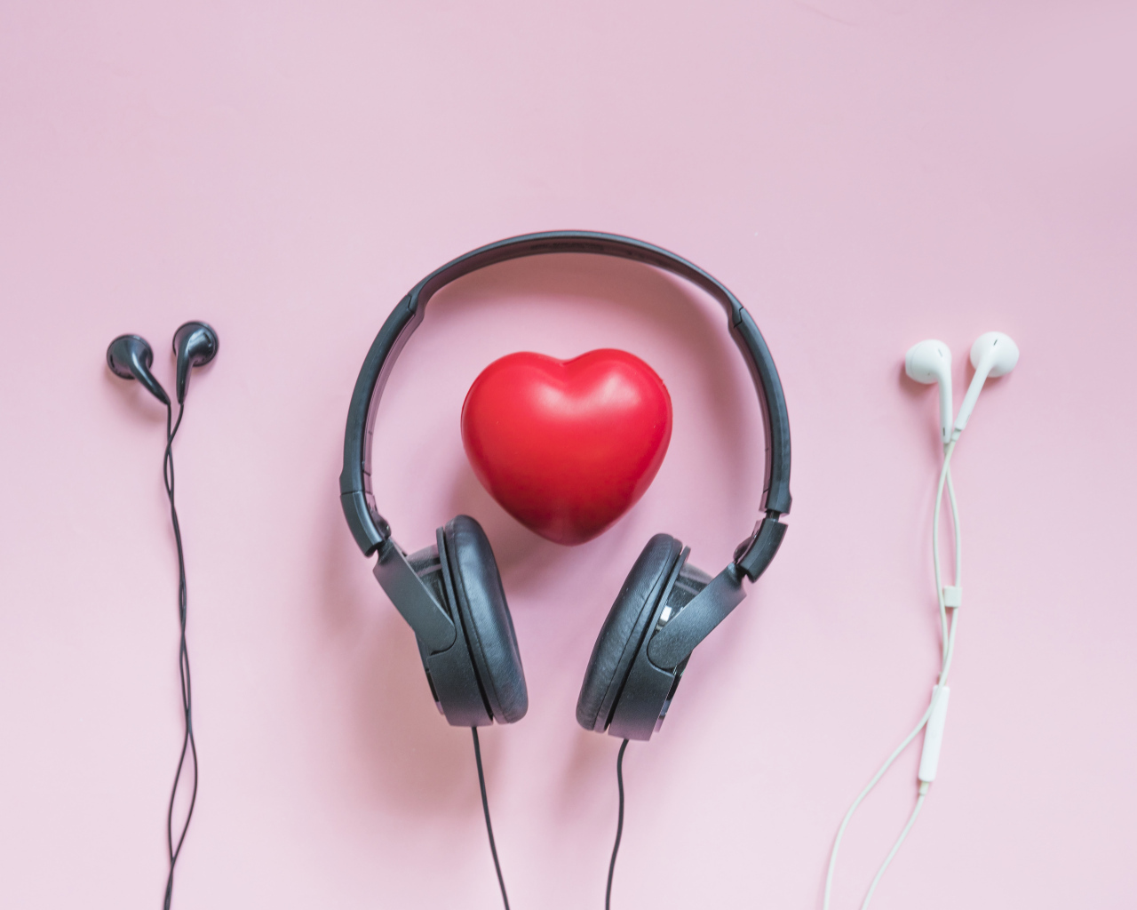 Наушники на розовом фоне с красным сердцем