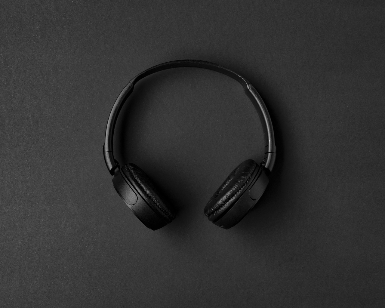Большие черные наушники на сером столе