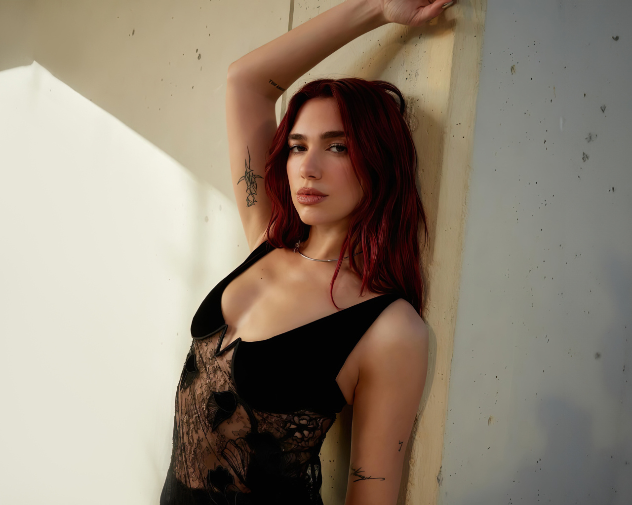 Певица Дуа Липа стоит у стены