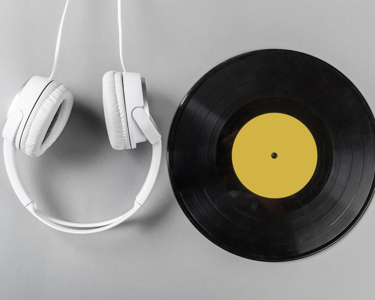 Виниловая пластинка и наушники на сером столе
