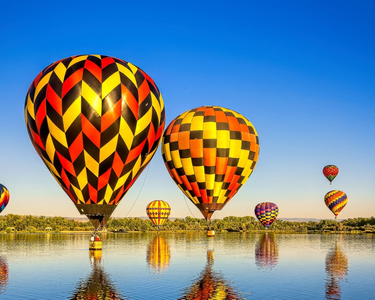 Большие воздушные шары над водой на фоне голубого неба