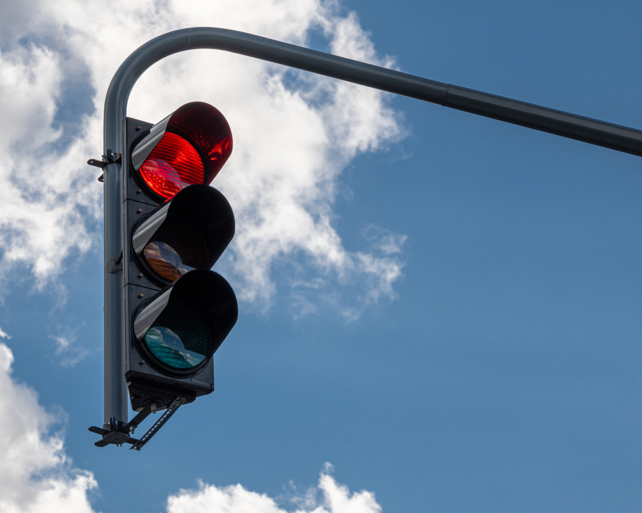 Красный свет светофора на фоне неба