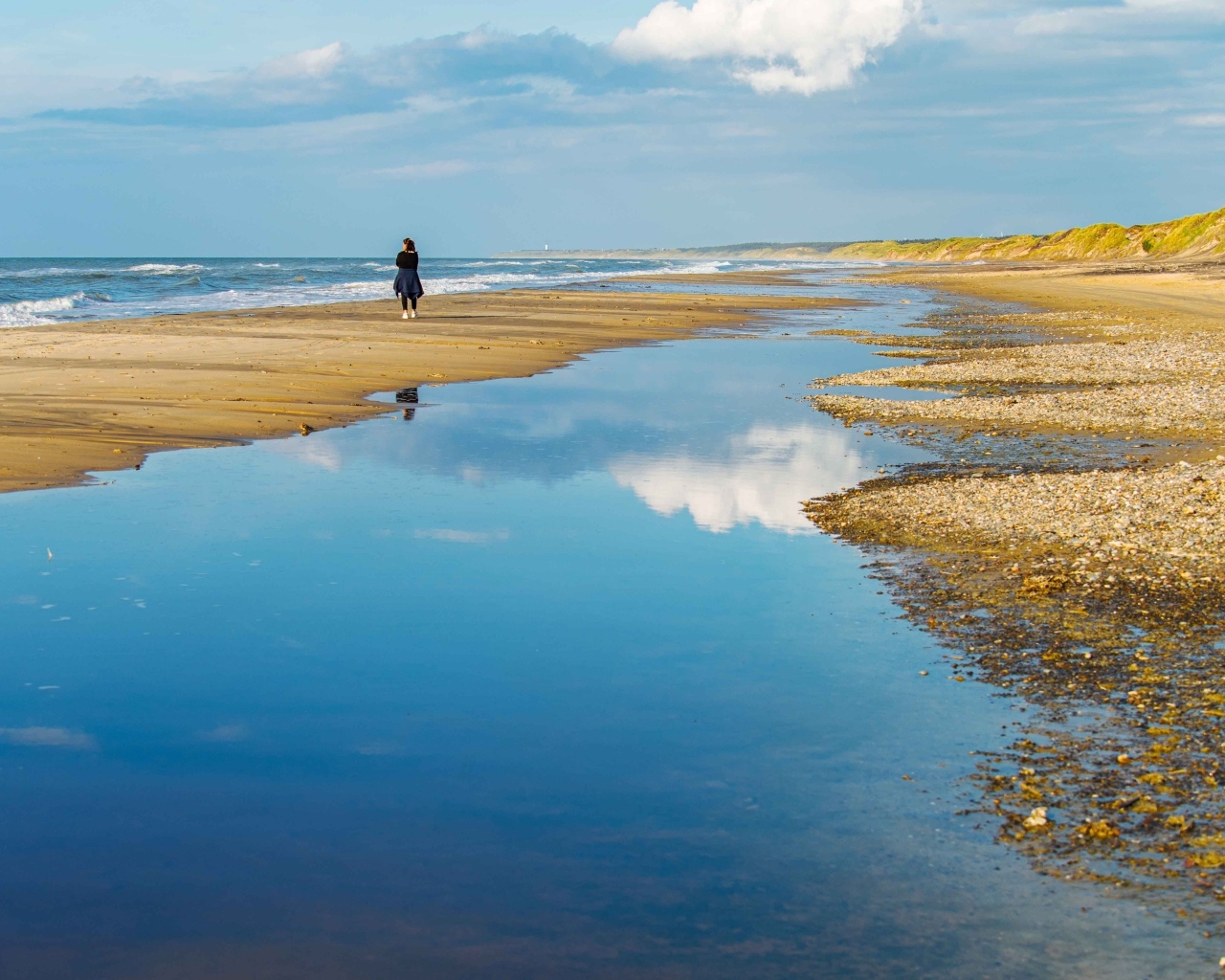 Небо отражается в воде на берегу моря