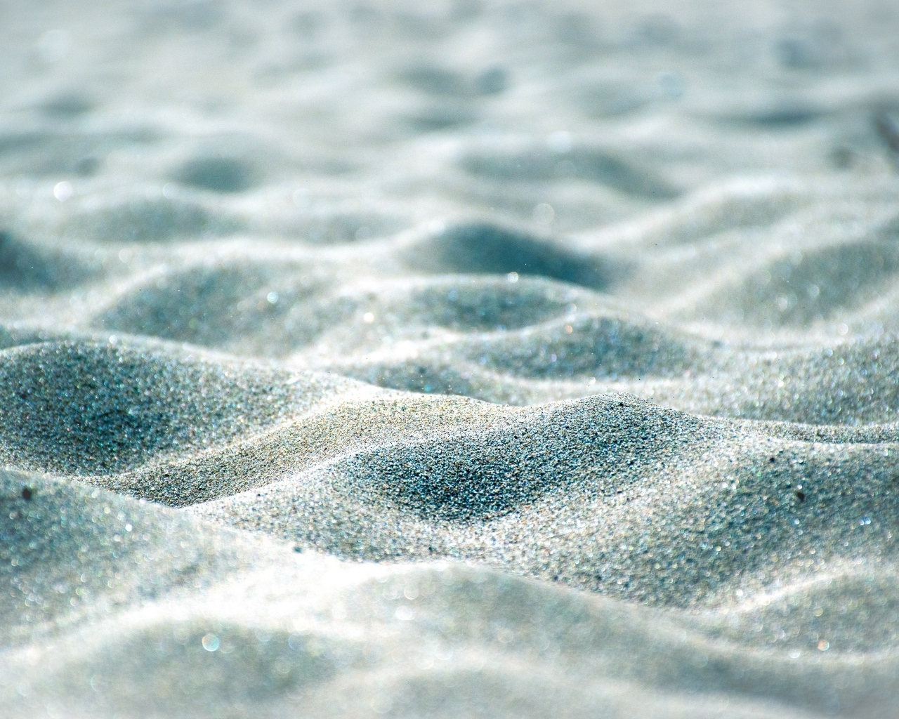 Блестящие волны песка на пляже