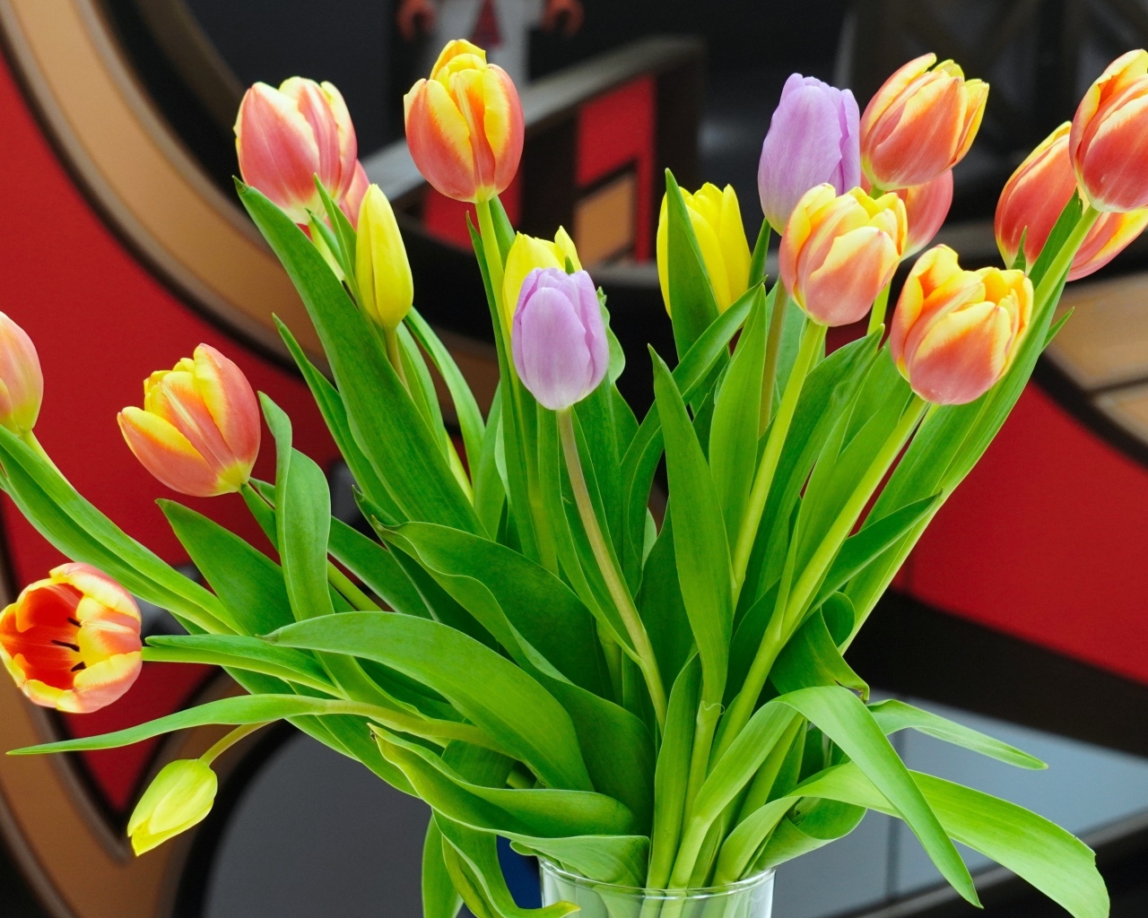 Букет красивых разноцветных тюльпанов в стеклянной вазе