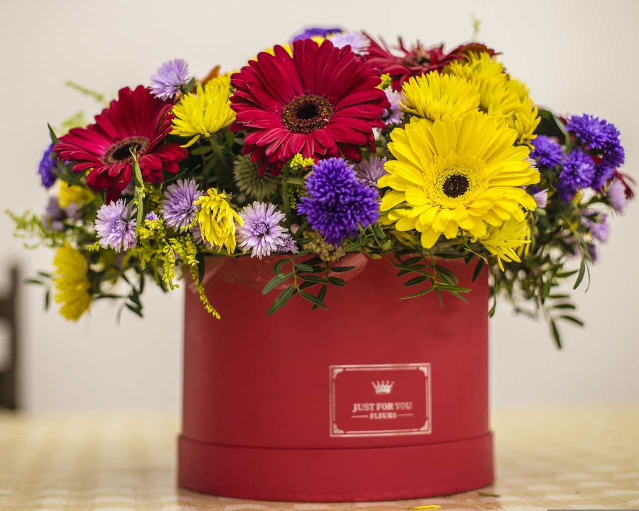 Букет разноцветных цветов в корочке на столе