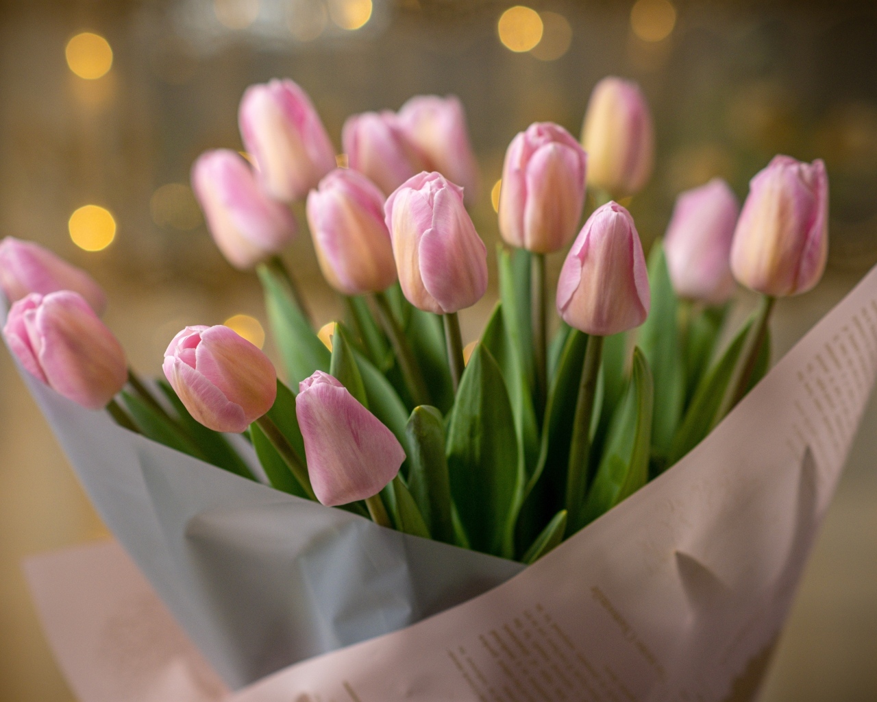 Букет розовых тюльпанов в бумажной упаковке в вазе