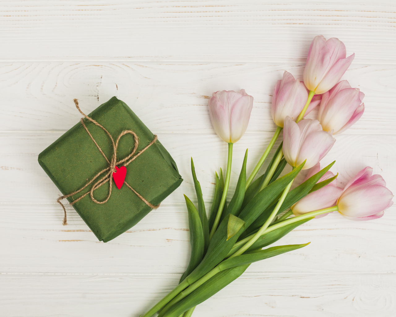 Букет розовых тюльпанов на столе с подарком