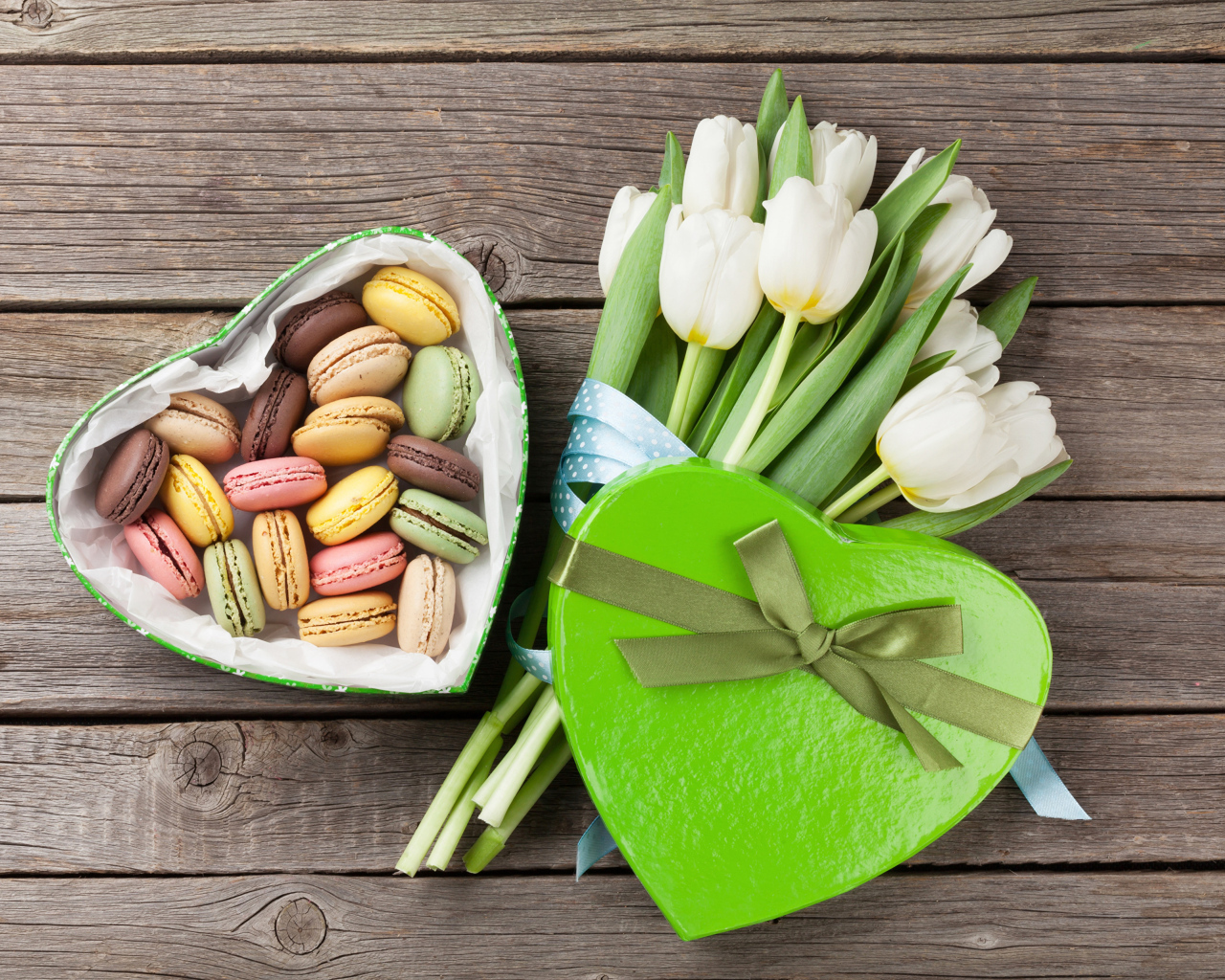 Букет белых тюльпанов на столе с коробкой печенья макарун